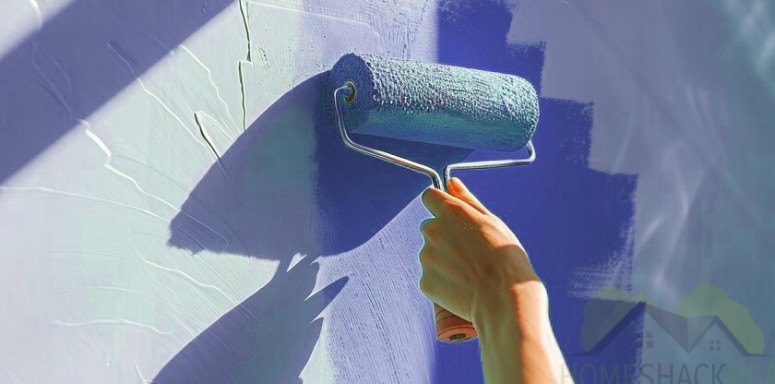 Hand holding a roller and do paint in a wall